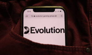 Evolution Gaming Group AB logo displayed on mobile phone hidden in a rusty-coloured corduroy pants pocket