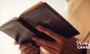 Close up of a bishop's hands holding an open bible. Group Of Ontario bishops are pushing for a sweeping ban of online gambling ads