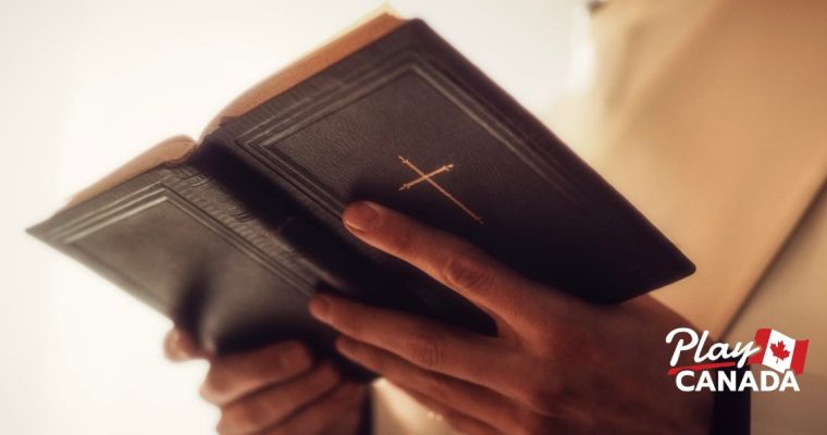 Close up of a bishop's hands holding an open bible. Group Of Ontario bishops are pushing for a sweeping ban of online gambling ads