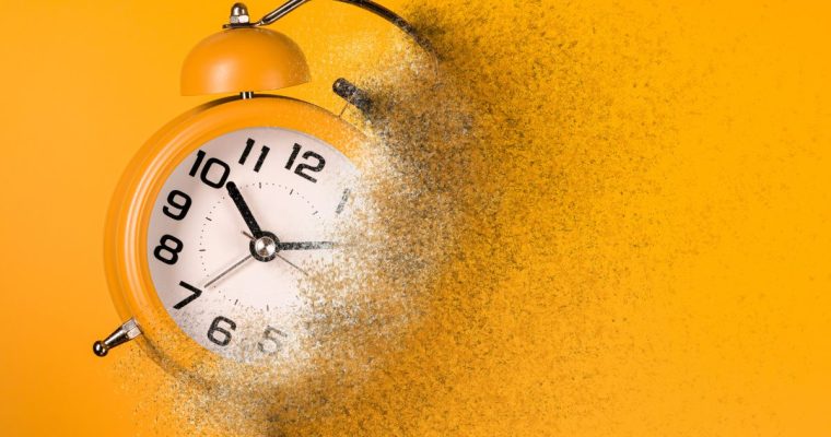 Dissolving orangey-yellow alarm clock on orangey-yellow background
