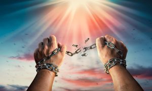 a set of hands breaking away from chains