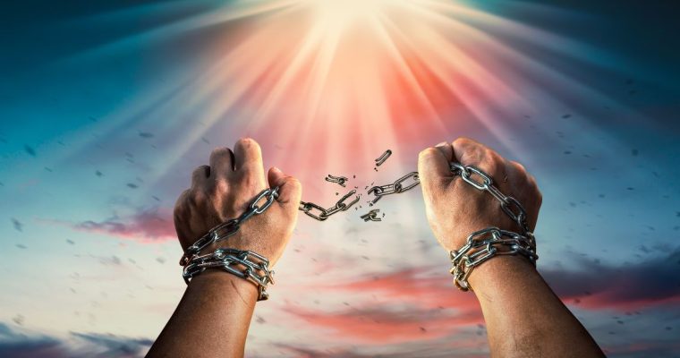 a set of hands breaking away from chains